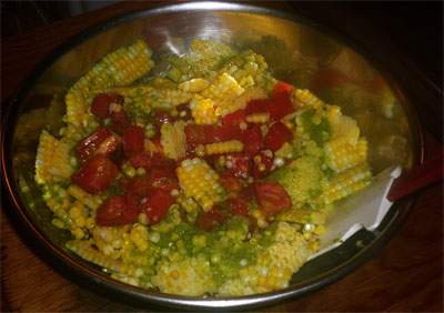 Mixing corn, tomatoes and vinaigrette