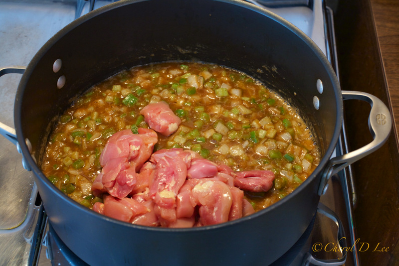 Adding chicken pieces to gumbo